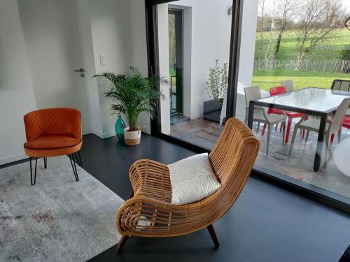 un salon avec une chaise en rotin et une table dans l'établissement Maison d'architecte avec SPA, à Concarneau