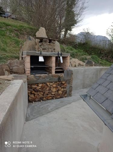 a brick oven with a pile of fire wood at Chalet Etxola in Ens