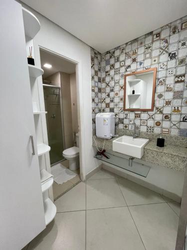 a bathroom with a sink and a toilet and a mirror at Landscape Beira Mar Fortaleza in Fortaleza