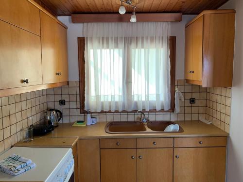 a kitchen with a sink and a window at Panormo House in Panormos Rethymno