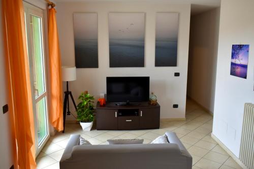 un soggiorno con divano e TV di Orange Apartment a Marina di Massa