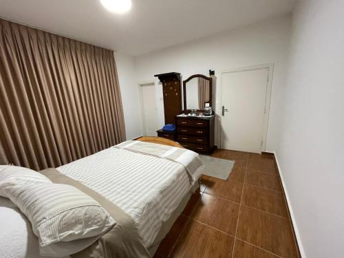 1 dormitorio con cama, tocador y espejo en Al-Daar, en ‘Ayn Amūn