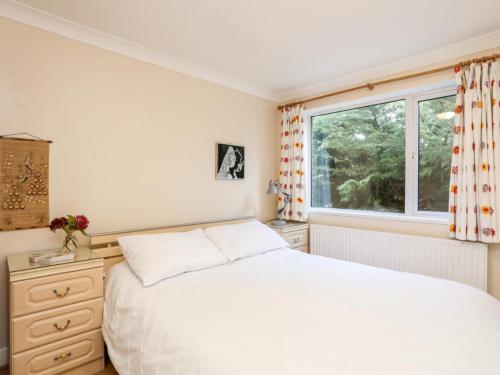 a bedroom with a white bed and a window at Queen's Cottage in Colwyn Bay
