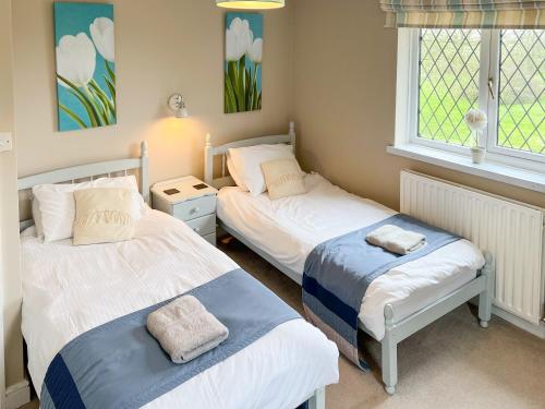a bedroom with two beds and a window at Archways-e1223 in Winthorpe