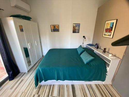 1 dormitorio con cama verde y espejo en Magnifique studio dans maisonnette, en Tourrettes-sur-Loup