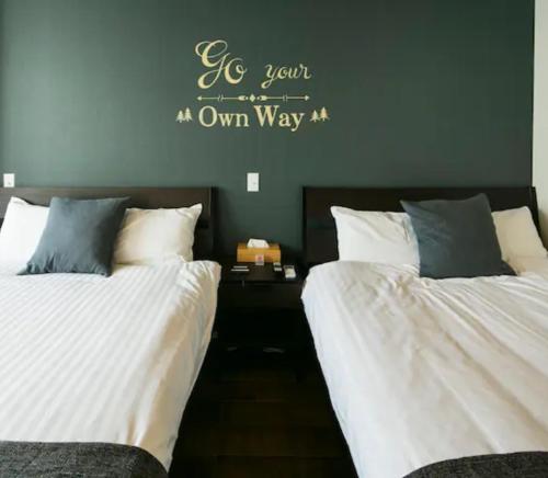 鹿兒島的住宿－ROI SPACE 鹿児島，两张睡床彼此相邻,位于一个房间里