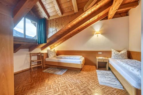 1 dormitorio con 2 camas y ventana en Ferienwohnungen Rebmannhof en Lana