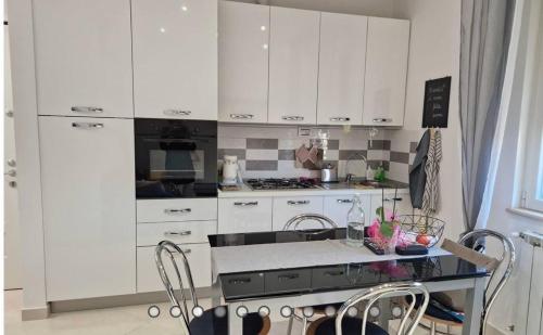 a kitchen with white cabinets and a table with chairs at A Casa di Ale Beach in Senigallia