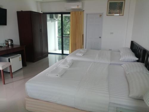 a bedroom with two large white beds in it at มุก&พลอย เรสซิเดนซ์ in Sattahip