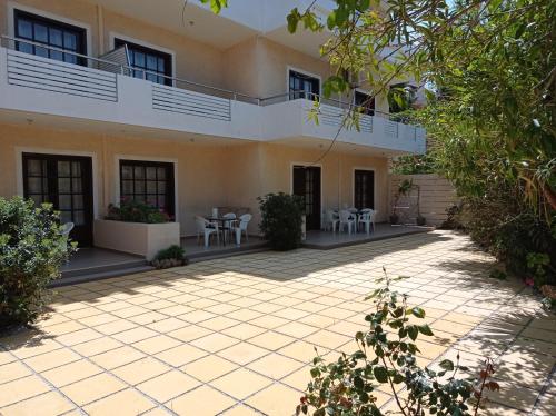 a courtyard of a house with tables and chairs at Alexandros Studios in Kalamaki Chanion