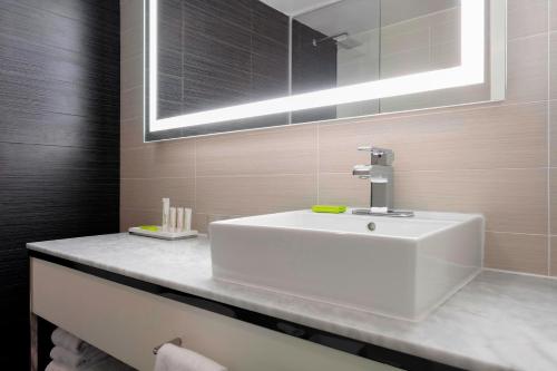 a bathroom with a white sink and a mirror at Le Méridien Charlotte in Charlotte