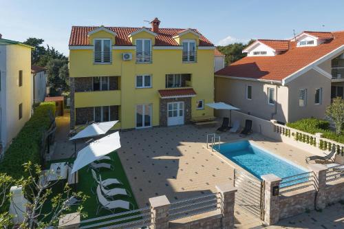 een luchtzicht op een huis met een zwembad bij Apartments Oliva in Vrsi