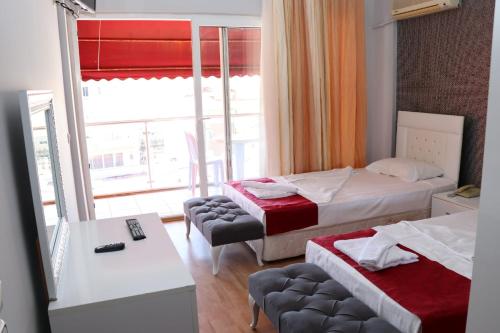 a hotel room with two beds and a window at Melody City Otel in Alanya