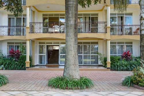 a building with a tree in front of it at Garden Courts Hotel Masaka in Masaka
