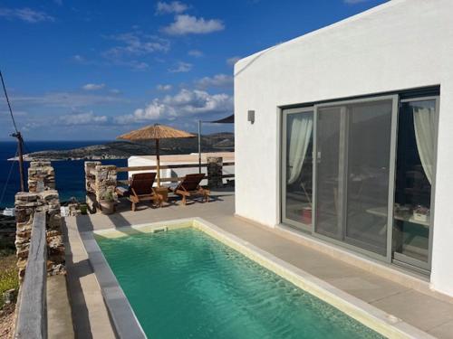 ein Pool vor einem Haus mit dem Meer in der Unterkunft Deja blue villa 2 in Agios Georgios