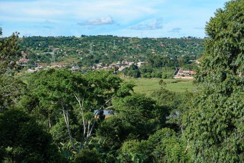 a view of a village from a hill with trees at Garden Courts Hotel Masaka in Masaka