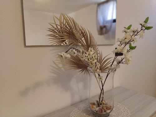 a vase with flowers in it on a table at STELLA MARINA, Appartamento a 450 mt dalla costa del Mar di Sardegna in Portoscuso