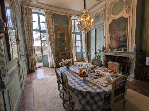 une salle à manger avec une table et une cheminée dans l'établissement Maison d'hôtes - Hôtel particulier de Jerphanion Cambacérès, au Puy-en-Velay