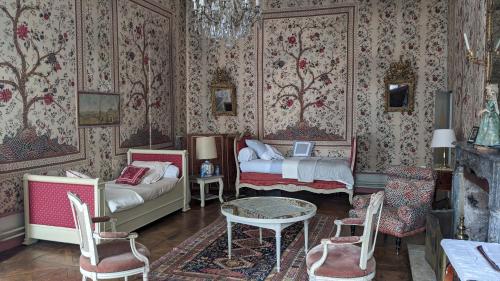 a bedroom with a bed and a table and chairs at Maison d'hôtes - Hôtel particulier de Jerphanion Cambacérès in Le Puy-en-Velay