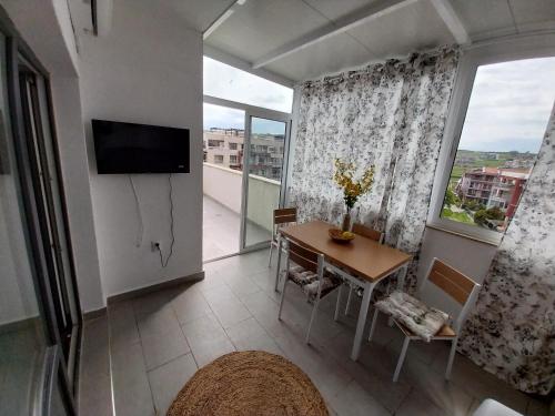 a living room with a table and a large window at Созопол Апартаменти AzurO in Sozopol