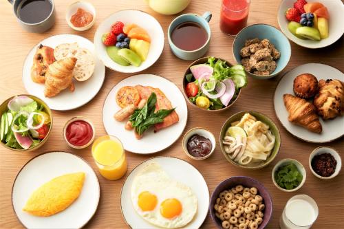 une table avec des assiettes et des bols de nourriture dans l'établissement Courtyard by Marriott Nagoya, à Nagoya