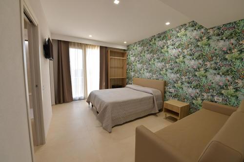 1 dormitorio con cama y pared de flores en L'OLEANDRO Room's - Suite & Spa da Giuseppe en Gonnosfanàdiga