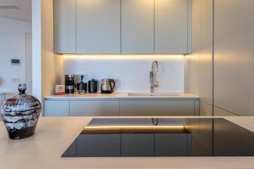 a kitchen with white cabinets and a vase on a counter at The Fetch - Residenze Esclusive sull'Acqua in Alghero