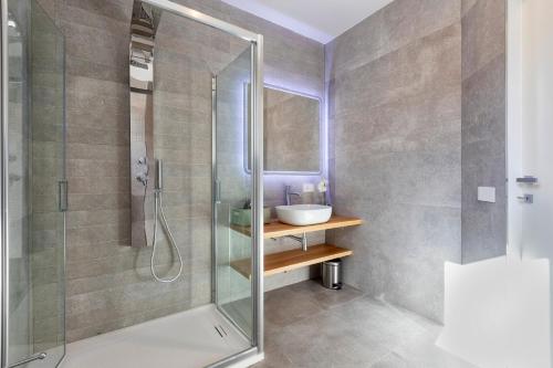 a bathroom with a glass shower and a sink at The Fetch - Residenze Esclusive sull'Acqua in Alghero