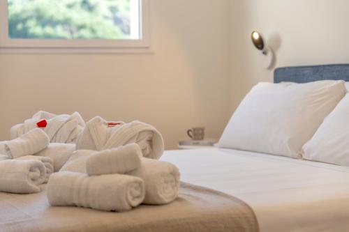 a pile of towels sitting on top of a bed at The Fetch - Residenze Esclusive sull'Acqua in Alghero