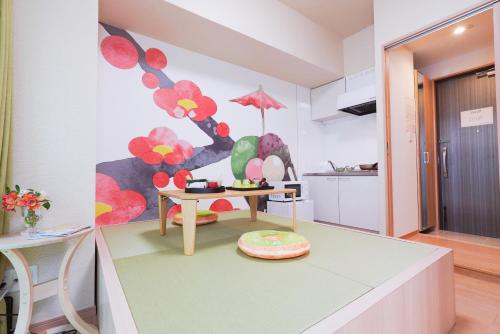 V の Boutique House في أوساكا: غرفة معيشة مع طاولة و لوحة على الحائط