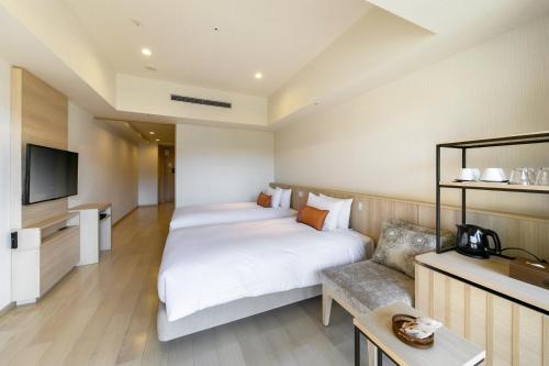a hotel room with two beds and a couch at Hakone Ashinoko Hanaori in Hakone