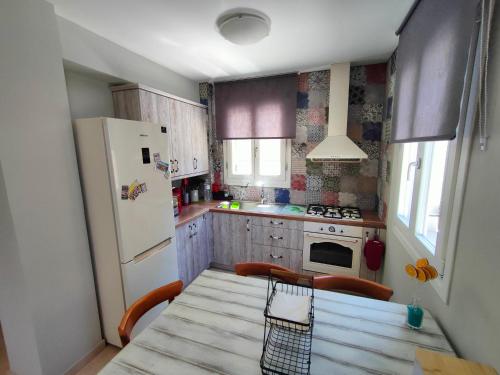 a small kitchen with a table and a refrigerator at Varko House in Vathi, Ithaka