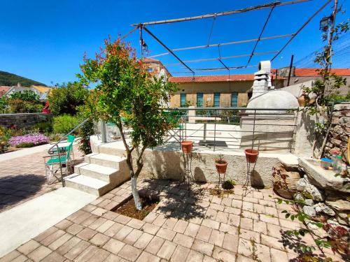 a small tree in a courtyard with a building at Varko House in Vathi, Ithaka