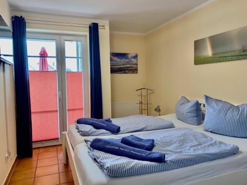 ボルテンハーゲンにある2 Zimmer Appartement Poseidonの青い枕が備わる客室内のベッド2台