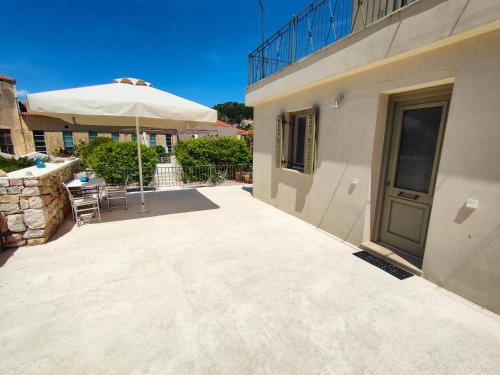 a patio with an umbrella next to a building at Varko House in Vathi, Ithaka