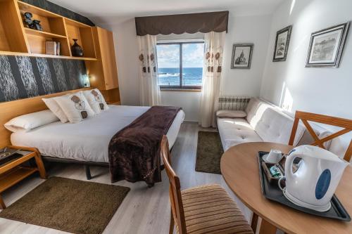 um quarto com uma cama, uma mesa e um sofá em Casa da Vasca em Malpica de Bergantiños