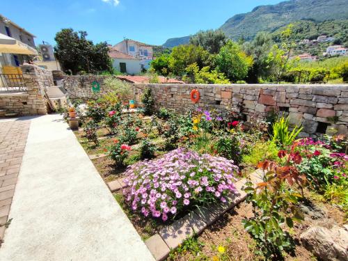 a garden with flowers and a stone wall at Varko House in Vathi, Ithaka