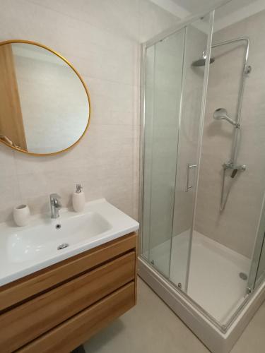 a bathroom with a sink and a shower with a mirror at DREAMS APARTMENT KAŠTELA in Kaštela