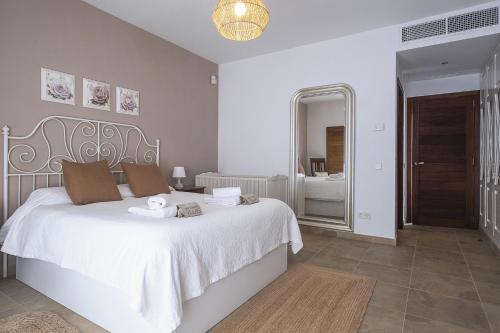 a bedroom with a large white bed and a mirror at Villa Racó de Sa Vinyeta in Sant Llorenç de Balafia