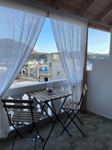 a table and chairs on a balcony with a view at WHITE STUDIOS in Himare