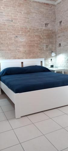a large bed in a room with a brick wall at LA RAJA in Scilla