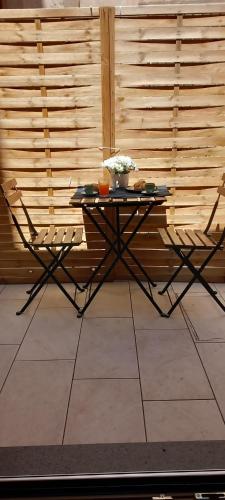 a table with two chairs in front of a wooden wall at LA RAJA in Scilla