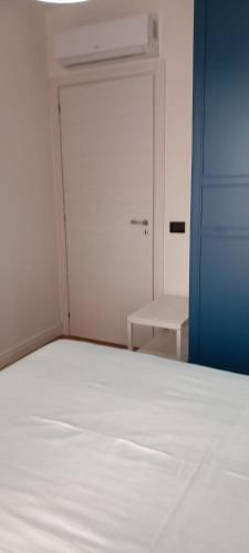 an empty bedroom with a white bed and a door at LA RAJA in Scilla
