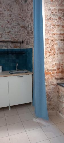 a bathroom with a sink and a blue curtain at LA RAJA in Scilla