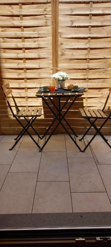 a table and two chairs in front of a wooden wall at LA RAJA in Scilla