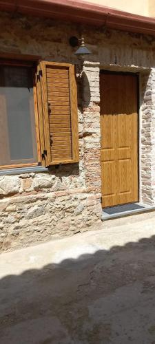 a stone building with a wooden door and windows at LA RAJA in Scilla