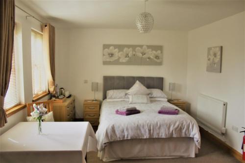 a bedroom with a bed and a table and a tub at Langdale Lodge in Lincoln