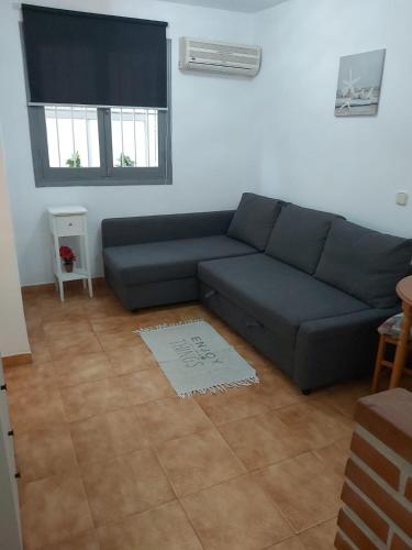 a living room with a blue couch and a window at Alemar I in Fuengirola
