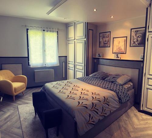 ein Schlafzimmer mit einem Bett, einem Stuhl und einem Fenster in der Unterkunft La Palmeraie in Saint-Père