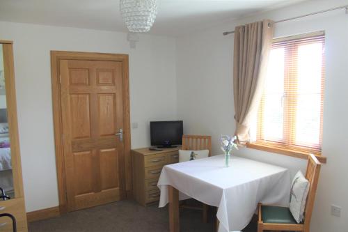a room with a table and a television and a door at Langdale Lodge in Lincoln